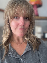 image of female model wearing handmade necklace with 3 tiny 14K yellow gold wire hearts on oxidized sterling silver chain