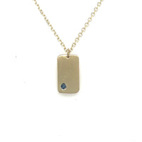 image of handmade 14K yellow furever dog tag necklace with small birthstone on 14K chain.