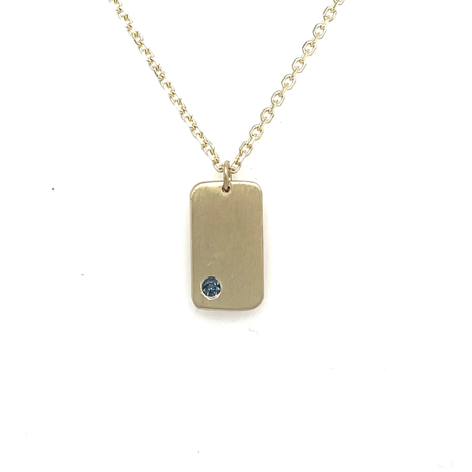 image of handmade 14K yellow furever dog tag necklace with small birthstone on 14K chain.
