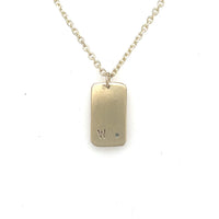 image of backside of handmade 14K yellow furever dog tag necklace showing custom engraving.