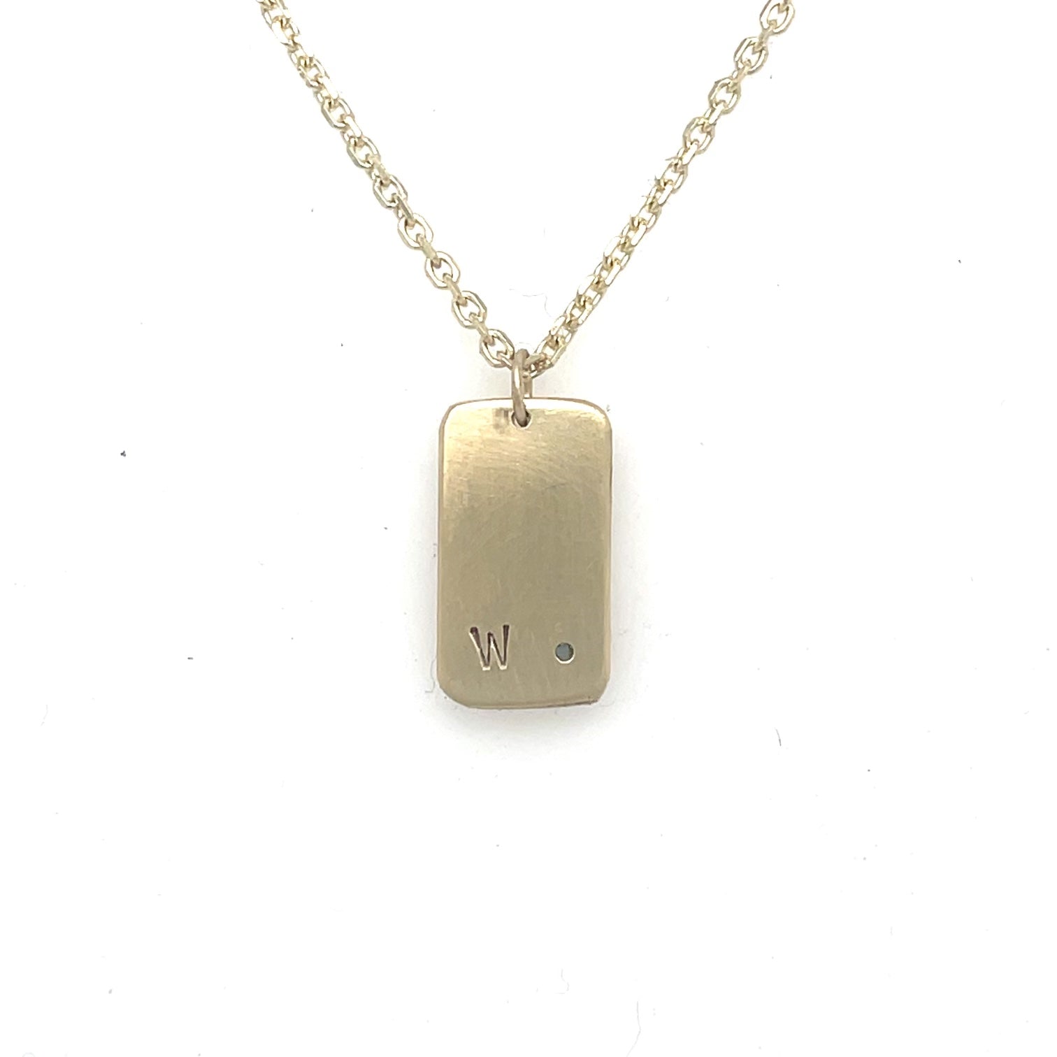 image of backside of handmade 14K yellow furever dog tag necklace showing custom engraving.
